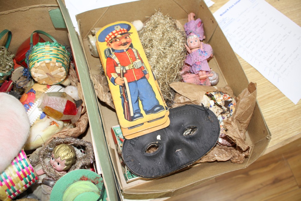 A collection of assorted curios, mostly vintage Christmas decorations but including masks and paper cut-outs